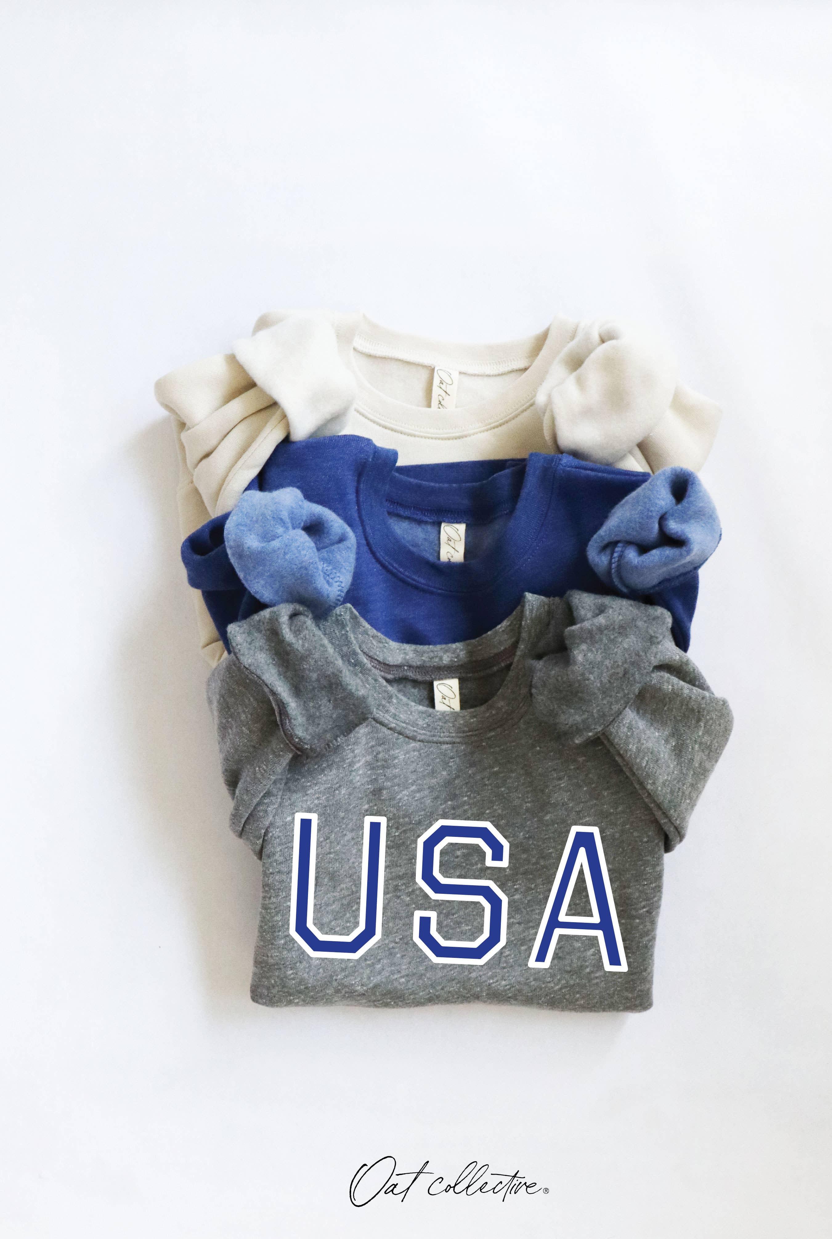 Stacked USA graphic tees in gray, blue, and cream for coastal PNW style
