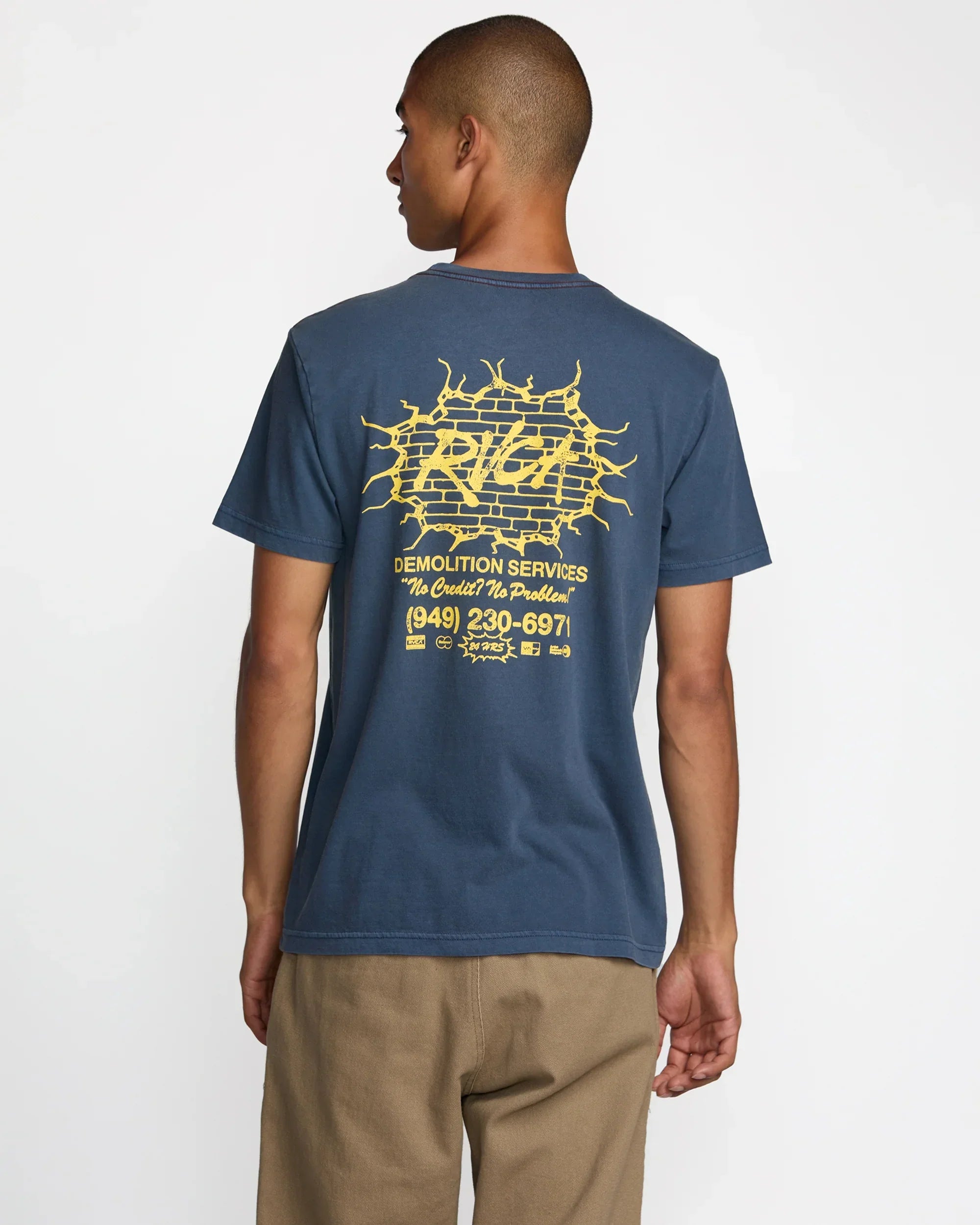 Man wearing blue graphic tee with yellow brick wall design, ideal for coastal PNW adventures and everyday style.