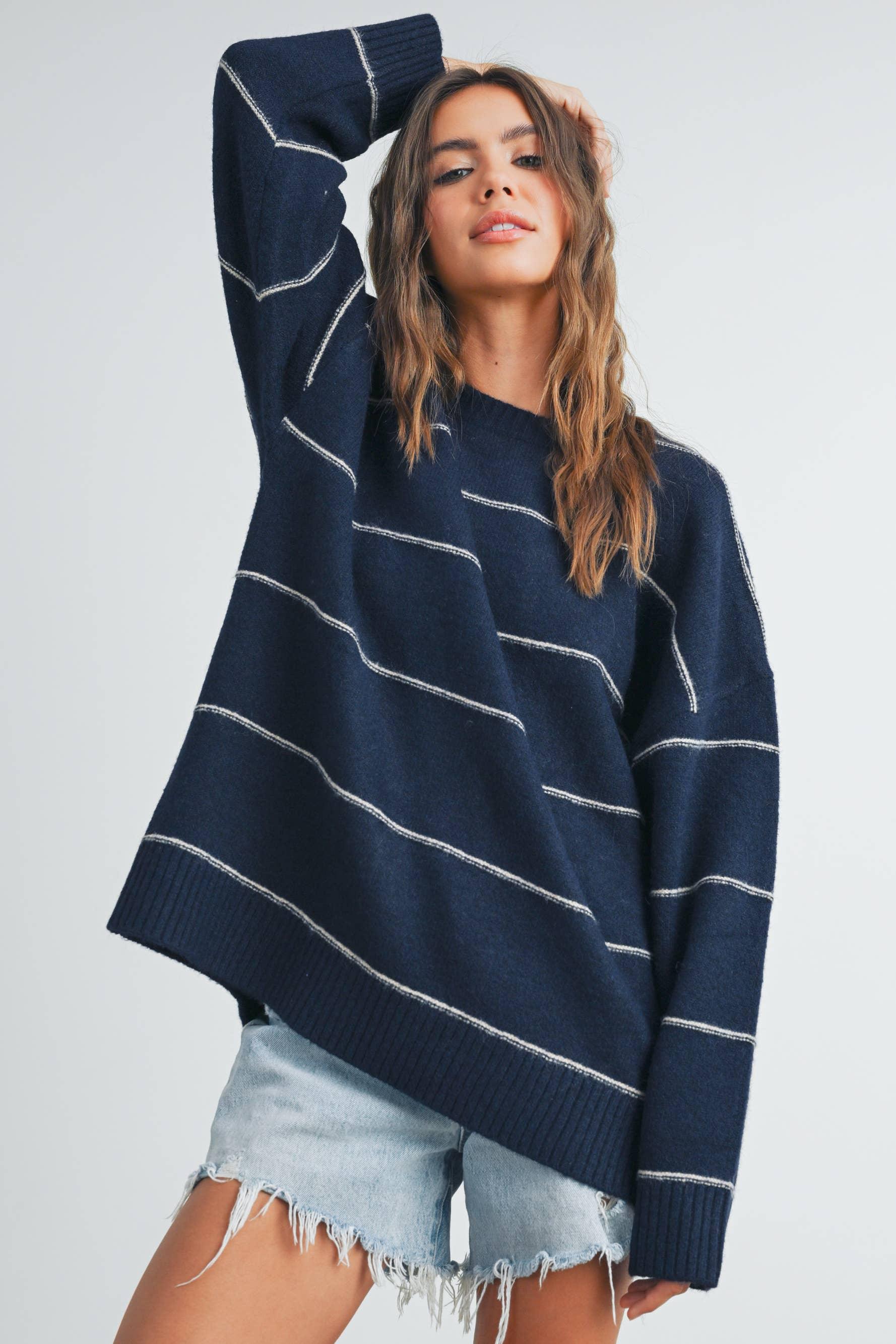 Navy blue striped oversized sweater with white lines, paired with distressed denim shorts