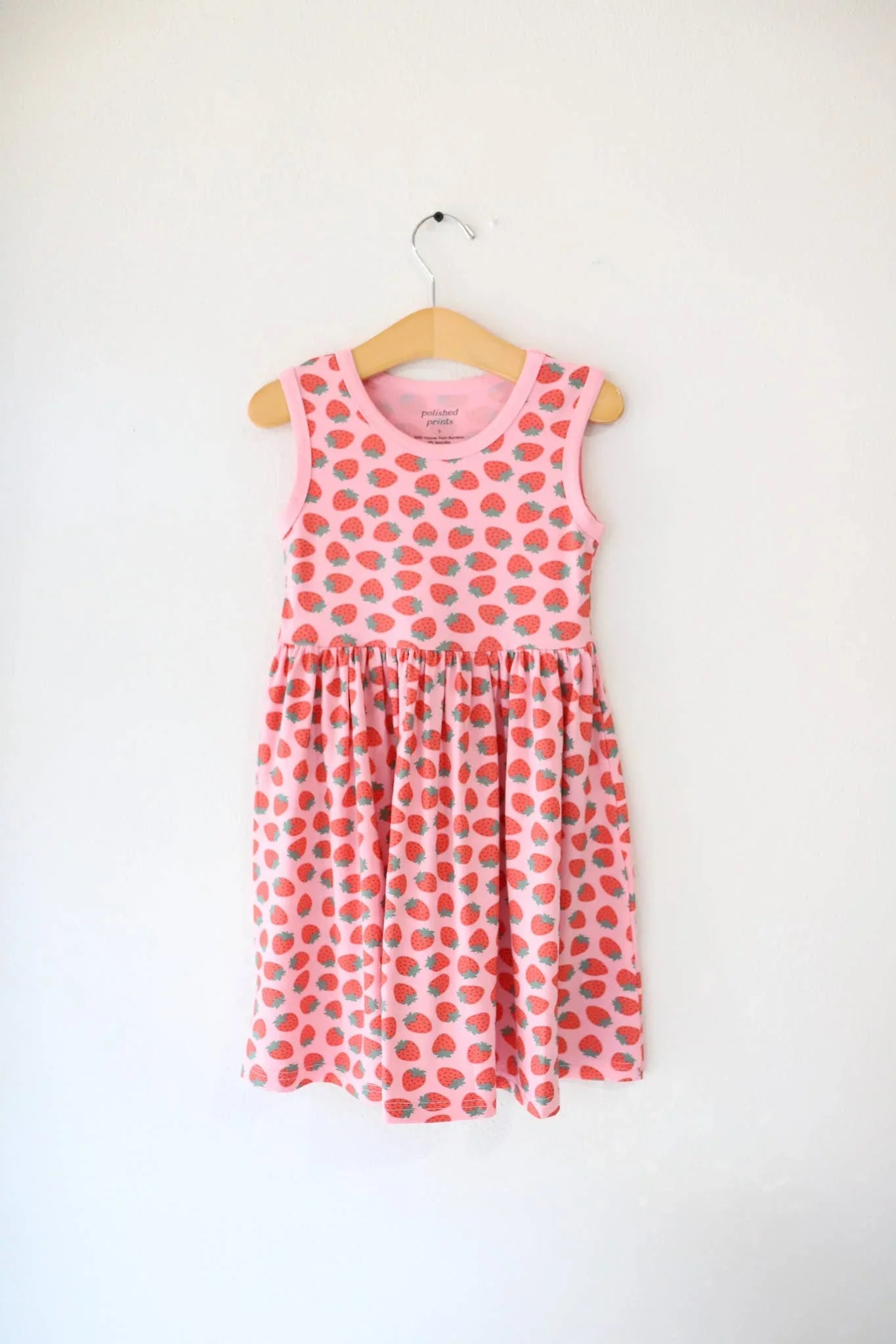 Pink strawberry print sleeveless dress for kids, perfect for beach days and coastal adventures