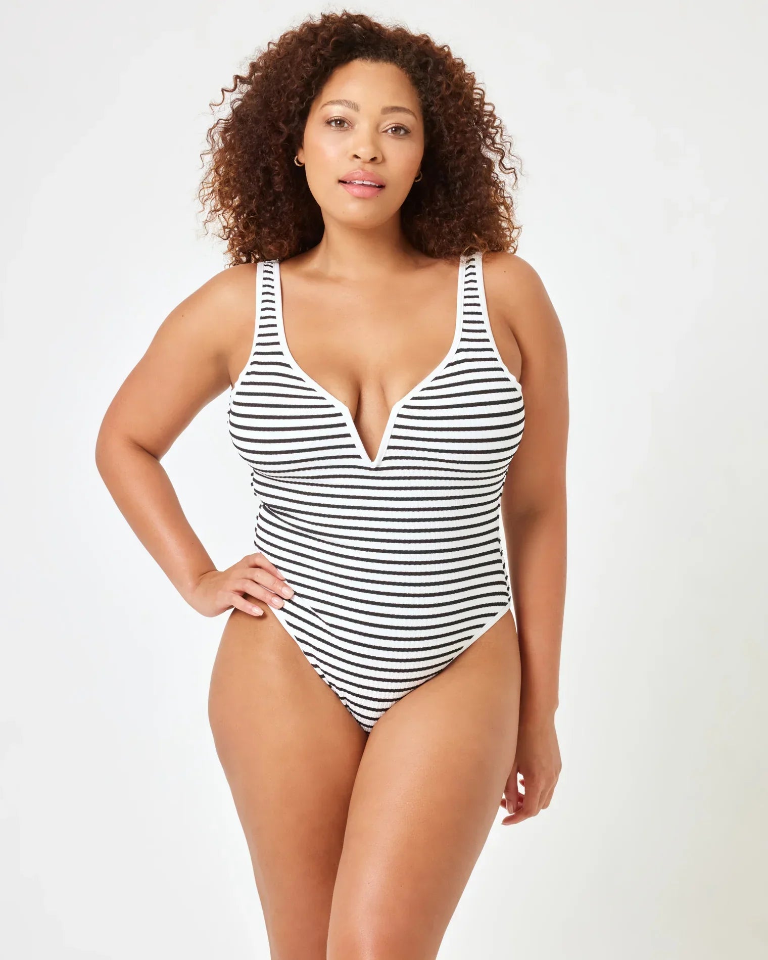 Plus size woman in black and white striped one-piece swimsuit with V-neck