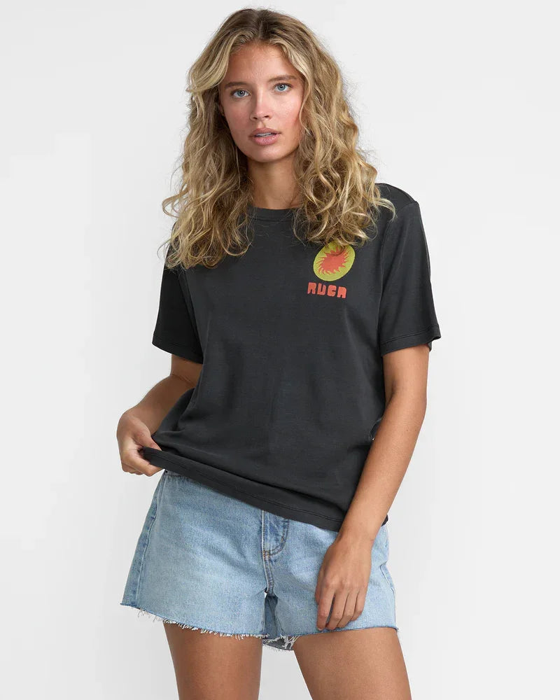 Black graphic tee with sunburst logo and 'RUGA' text, paired with denim shorts for coastal PNW style