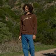 Man in brown hoodie and blue pants hiking coastal trail, PNW outdoor adventure gear