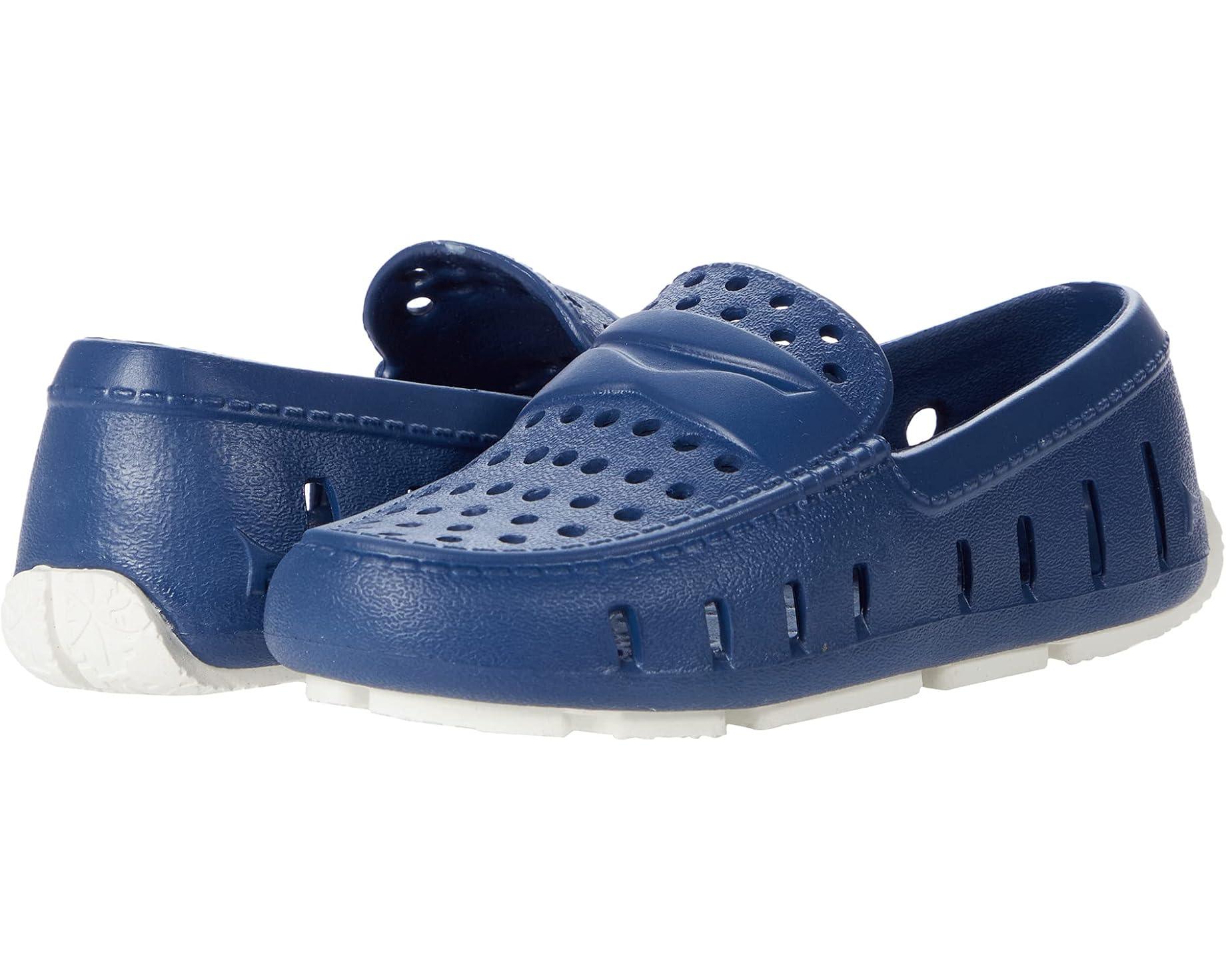 Navy blue perforated slip-on shoes with white soles, ideal for casual wear or outdoor activities.