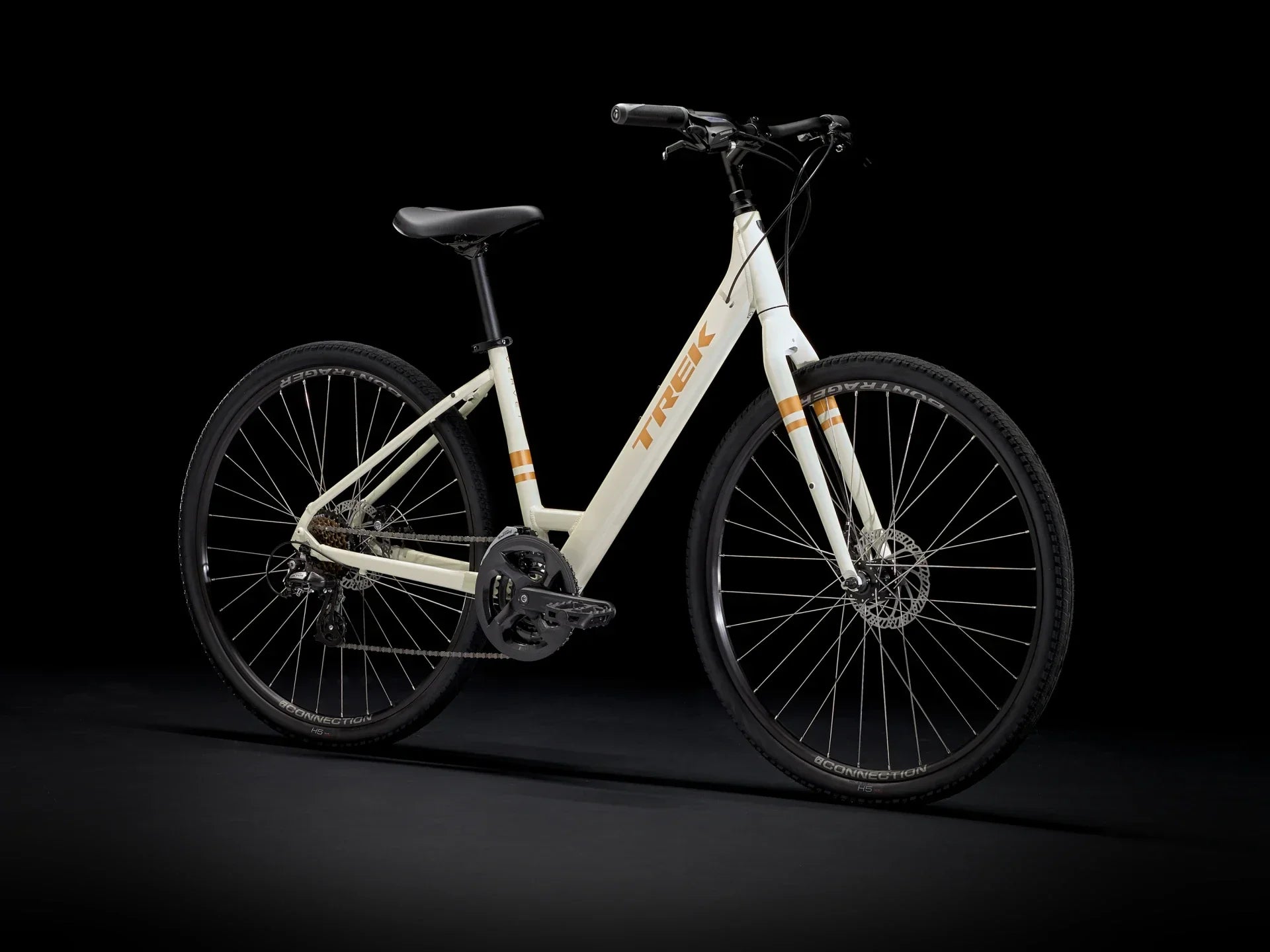 White Trek hybrid bike with orange accents, disc brakes, and sleek frame design