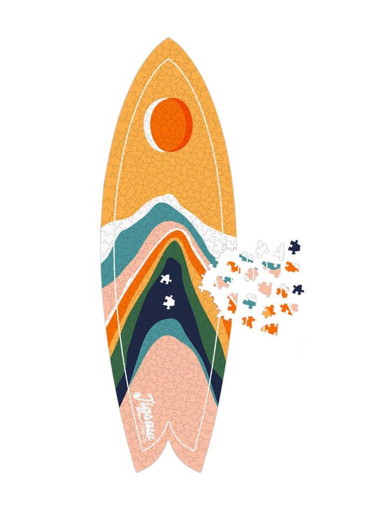 Colorful surfboard puzzle with mountain design and scattered pieces