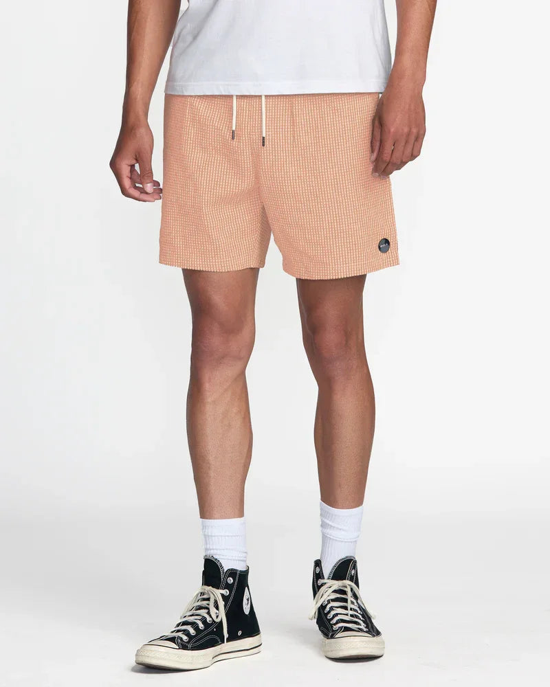 Peach gingham board shorts with drawstring waist, styled with white tee and black high-top sneakers for coastal casual wear