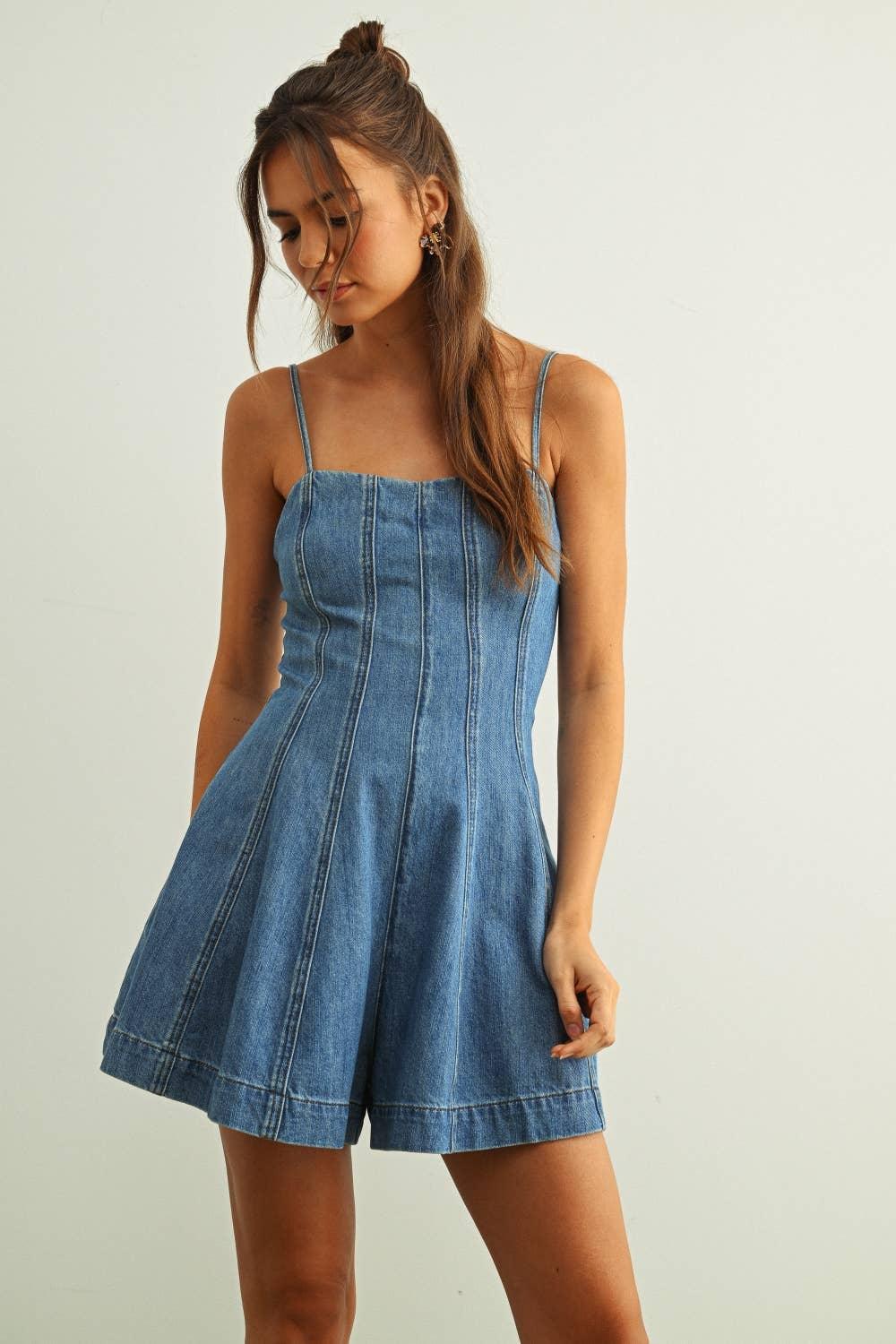 Woman wearing blue denim romper with thin straps and flared shorts, casual summer outfit