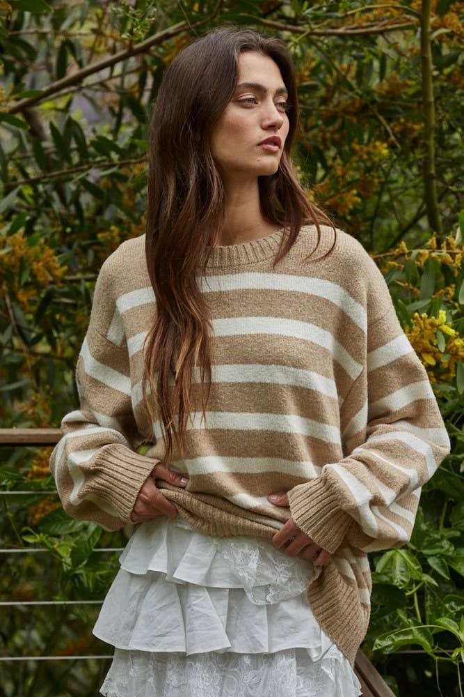 Woman in cozy striped sweater and ruffle skirt, perfect for PNW outdoor style and coastal adventures.