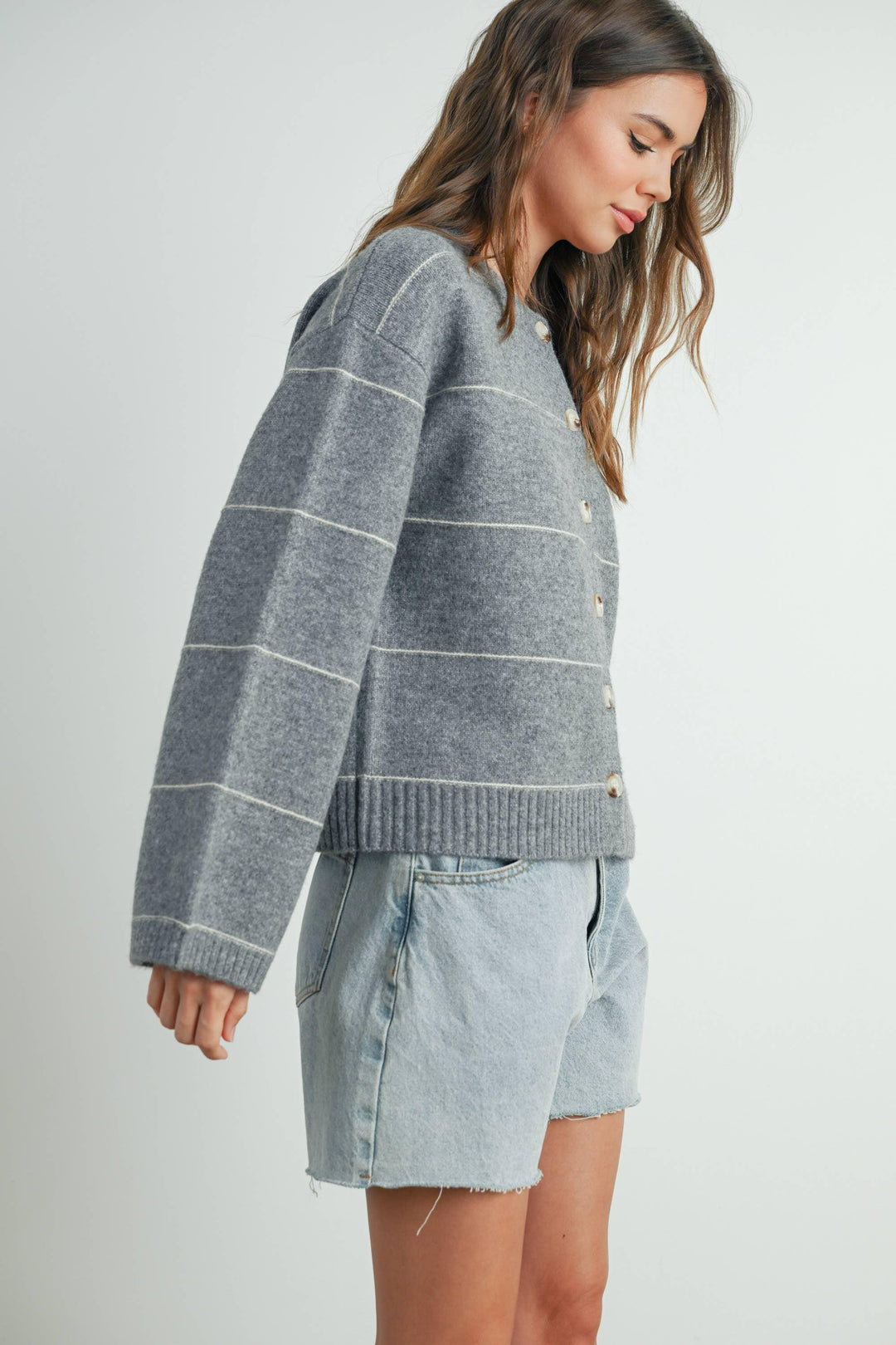 Gray striped button-up cardigan with light denim shorts, coastal style outfit