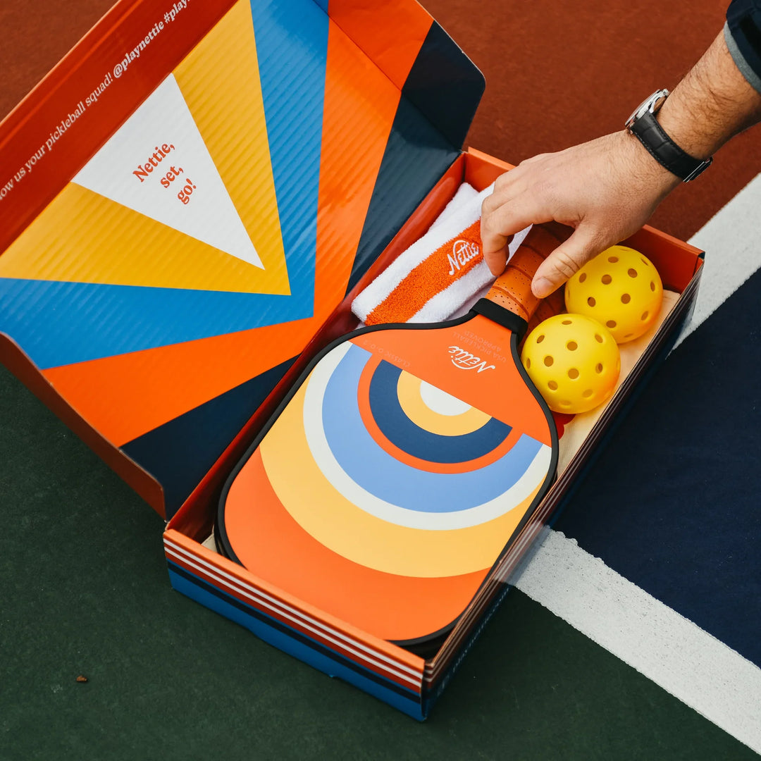 Nettie pickleball paddle set with balls and towel in colorful box on court