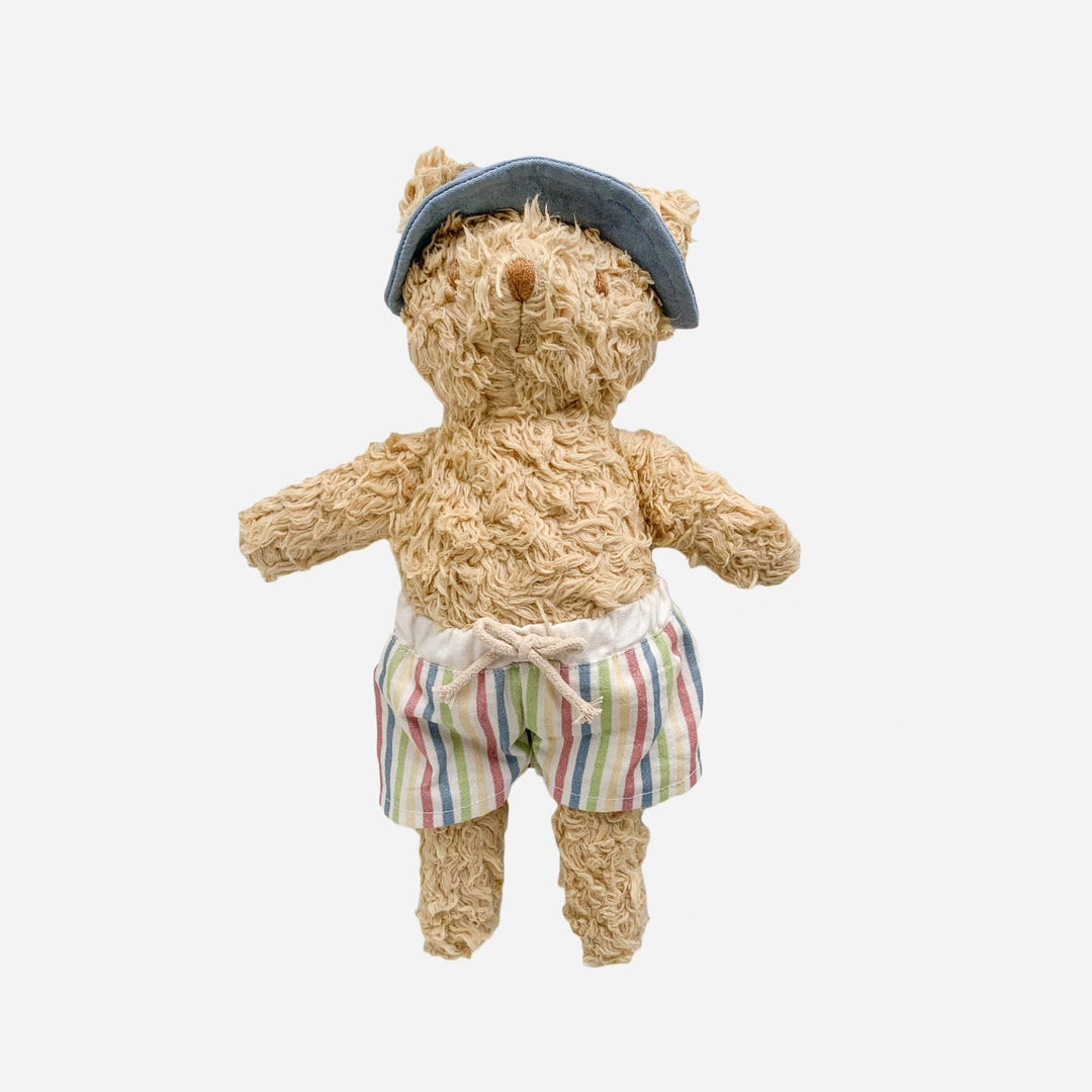 Fluffy teddy bear in striped swim trunks and blue cap, perfect for beach days and coastal adventures.
