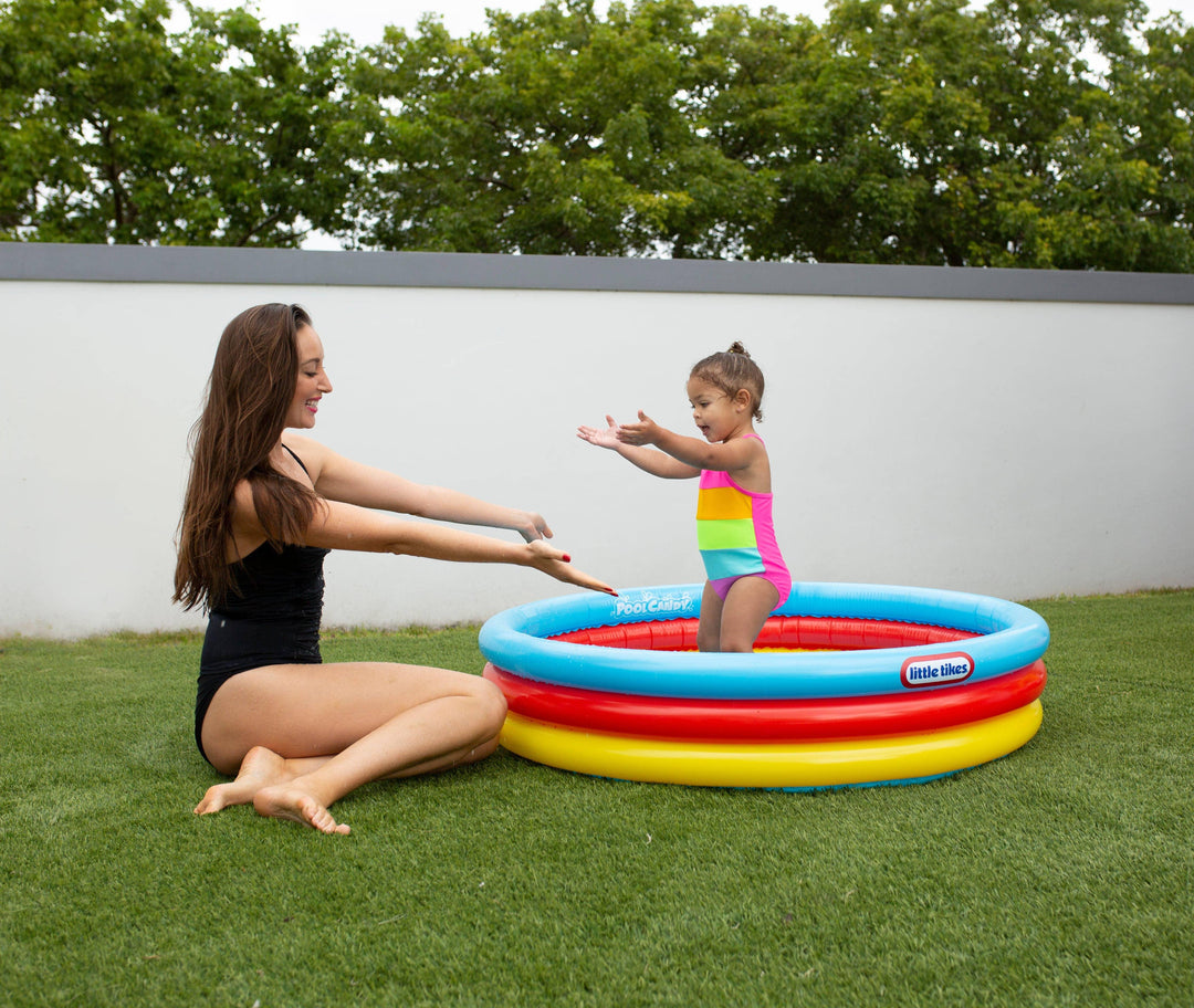 Mom and toddler playing in colorful Little Tikes inflatable pool on grass, perfect for backyard summer fun.