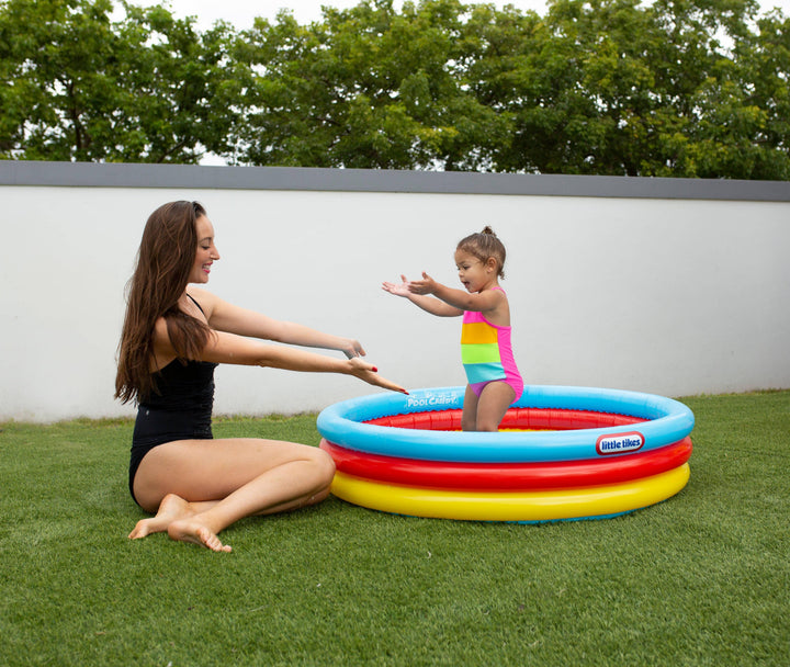 Mom and toddler playing in colorful Little Tikes inflatable pool on grass, perfect for backyard summer fun.