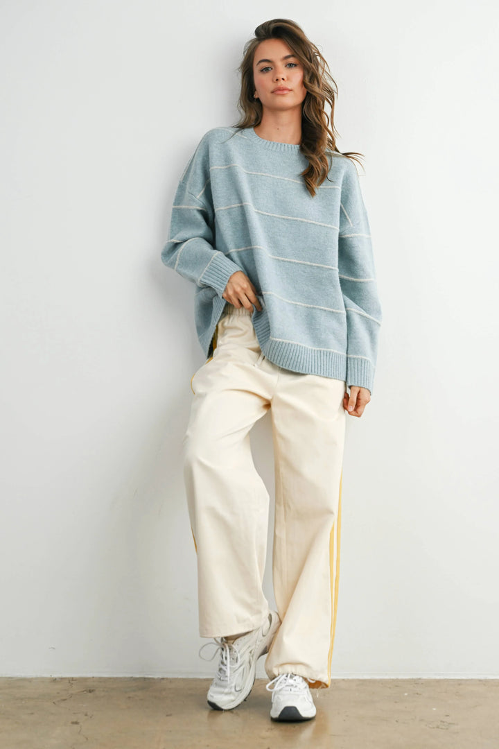 Woman in light blue striped sweater and cream wide-leg pants, coastal PNW style outfit