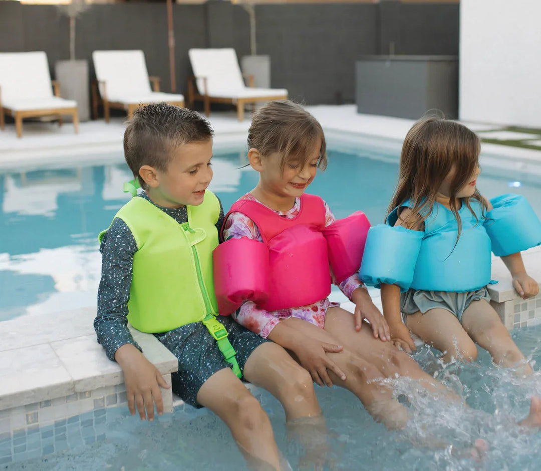 Kids wearing colorful swim vests by poolside, enjoying water fun safely