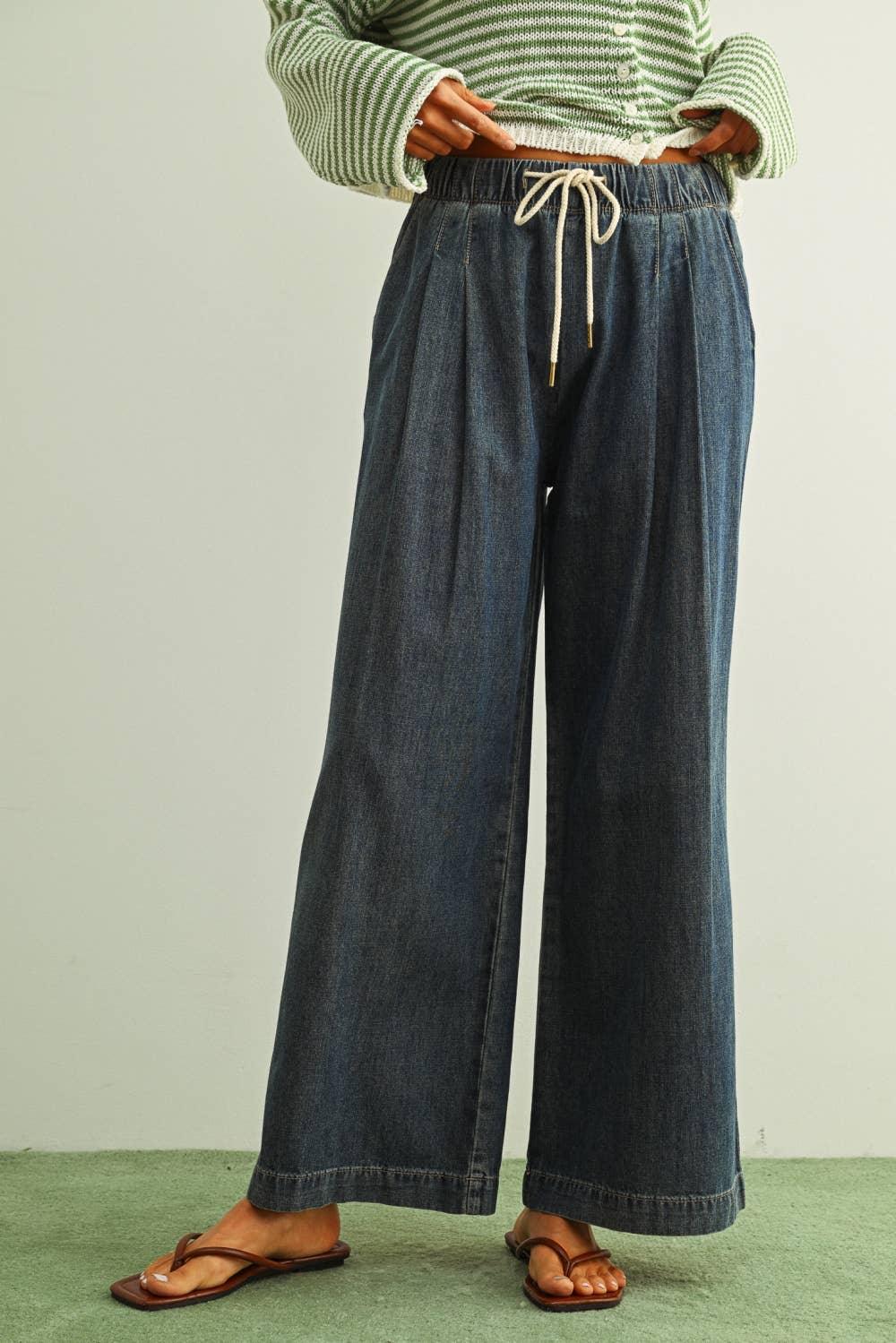 Wide-leg denim pants with drawstring waist paired with green striped top and sandals