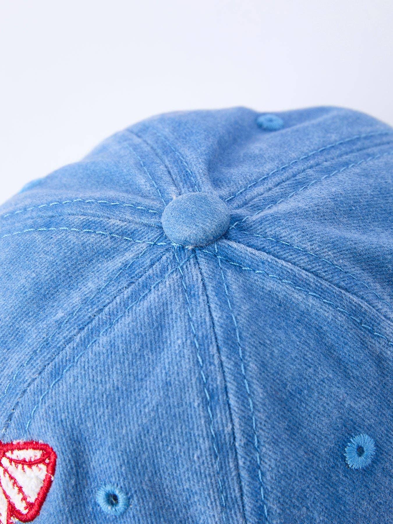 Blue denim baseball cap with red and white embroidered patch, ideal for outdoor adventures and coastal style.