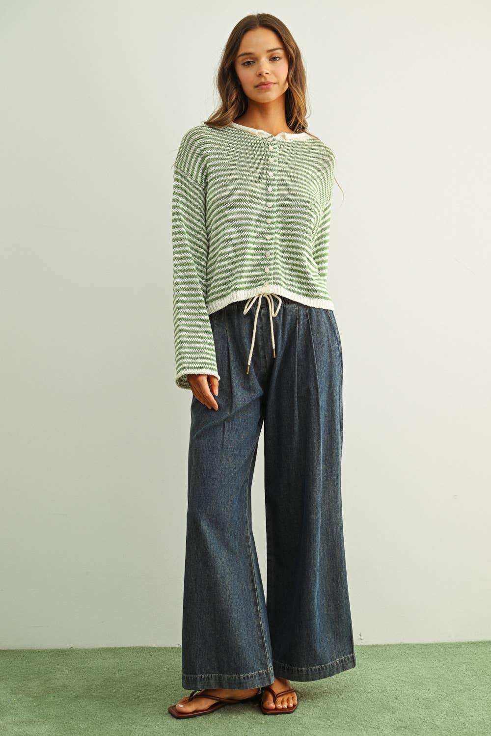 Woman wearing green striped knit cardigan with wide-leg denim pants and sandals