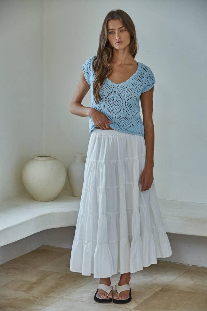 Woman in light blue crochet top and white tiered skirt, casual summer outfit