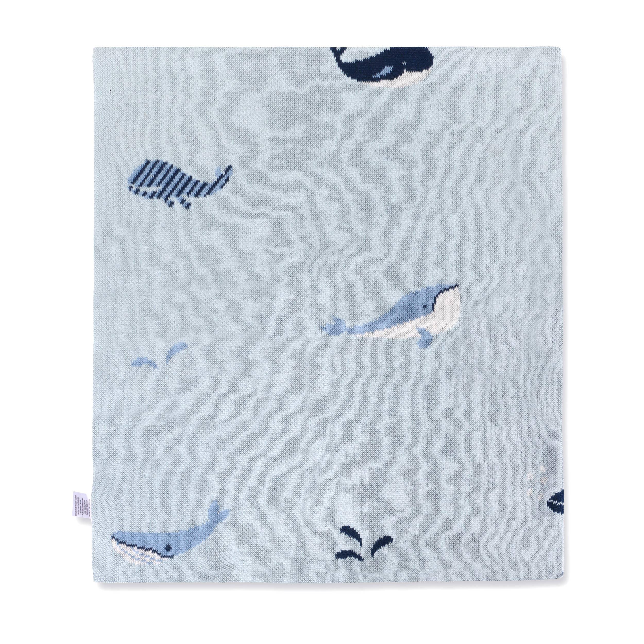 Light blue knit blanket with playful whale and fish patterns, soft texture for baby or nursery use