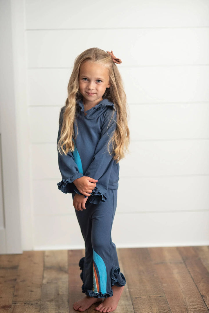 Girl in blue ruffle pajama set with teal stripe, cozy coastal kids loungewear