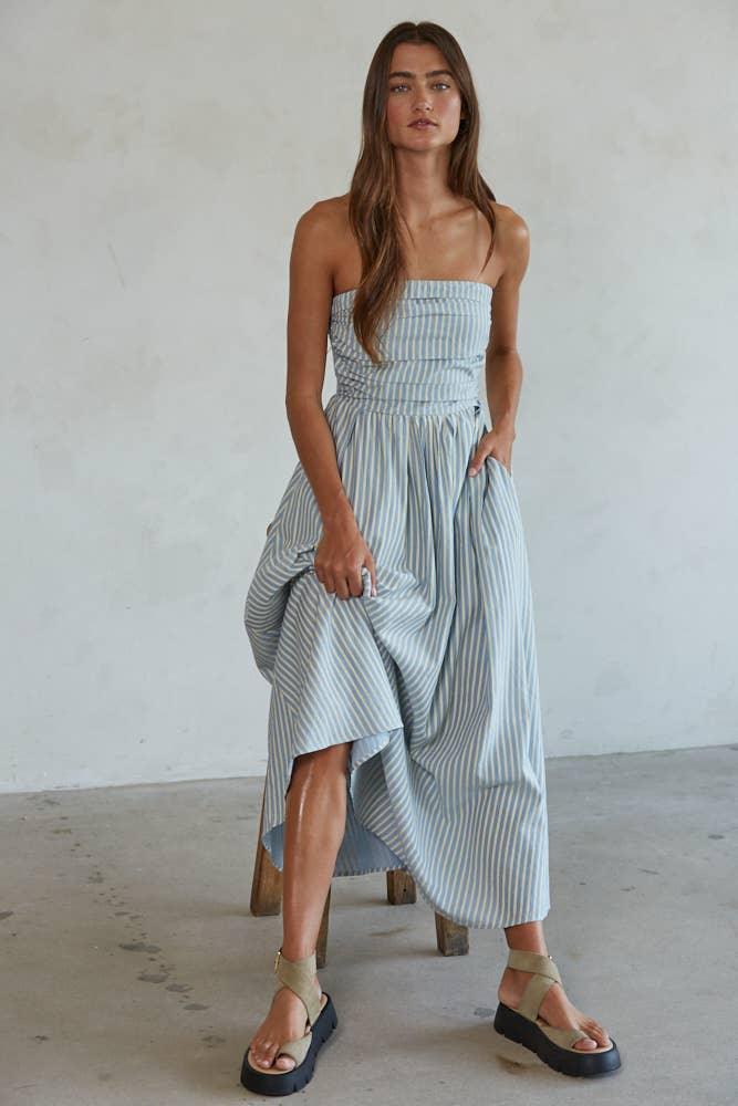 Woman in striped strapless maxi dress with pockets, paired with platform sandals, coastal style