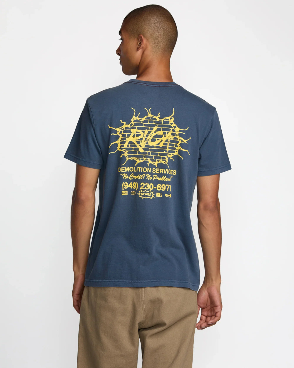 Man wearing blue graphic tee with yellow brick wall design, ideal for coastal PNW adventures and everyday style.