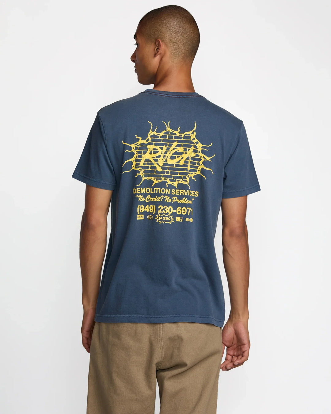 Man wearing blue graphic tee with yellow brick wall design, ideal for coastal PNW adventures and everyday style.