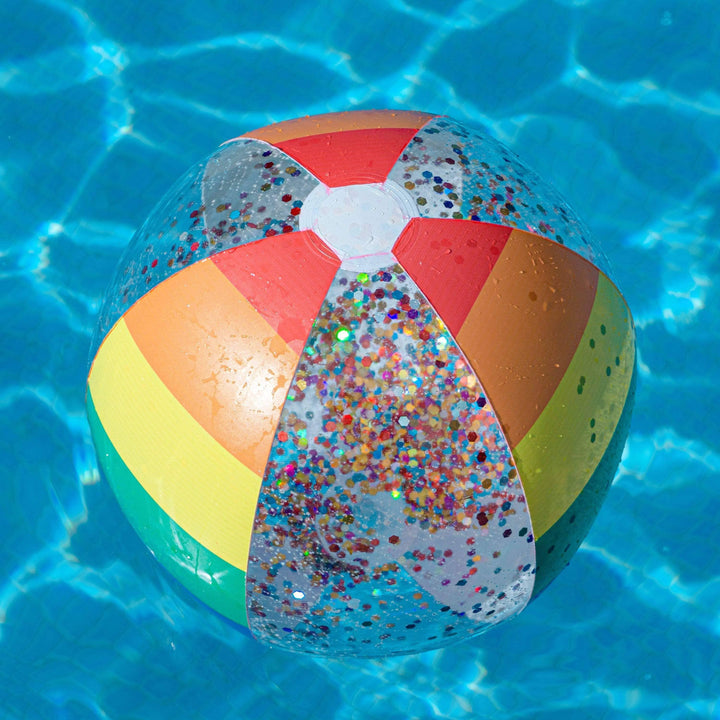 Colorful glitter beach ball floating in pool water, perfect for summer fun and outdoor adventures.