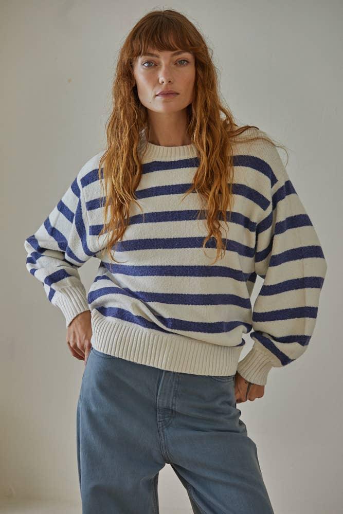 Woman in cozy blue and cream striped sweater, coastal style outfit