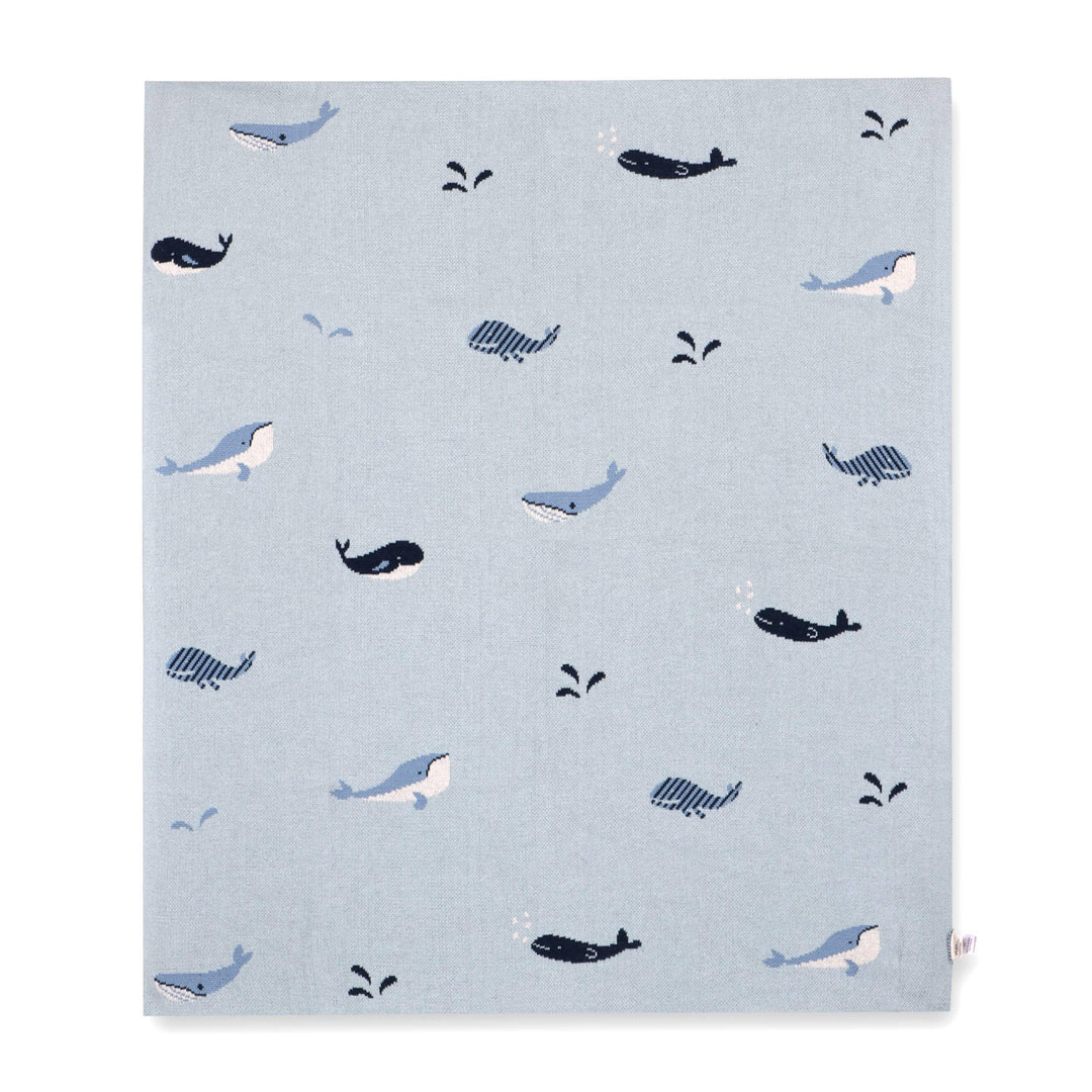 Light blue blanket with playful whale and splash patterns, ideal for baby nurseries or ocean-themed decor.