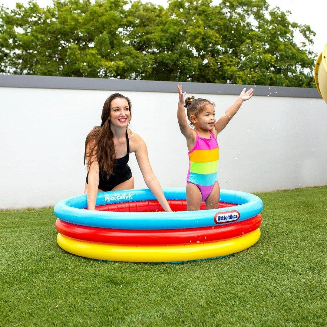 Mom and toddler playing in colorful Little Tikes inflatable pool on grass, perfect for backyard summer fun.