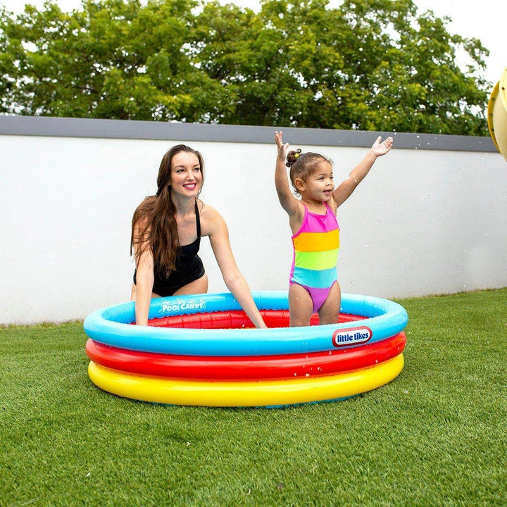 Mom and toddler playing in colorful Little Tikes inflatable pool on grass, perfect for backyard summer fun.