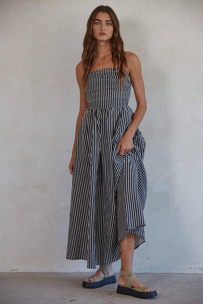 Woman in black and white striped strapless maxi dress with platform sandals, coastal style outfit