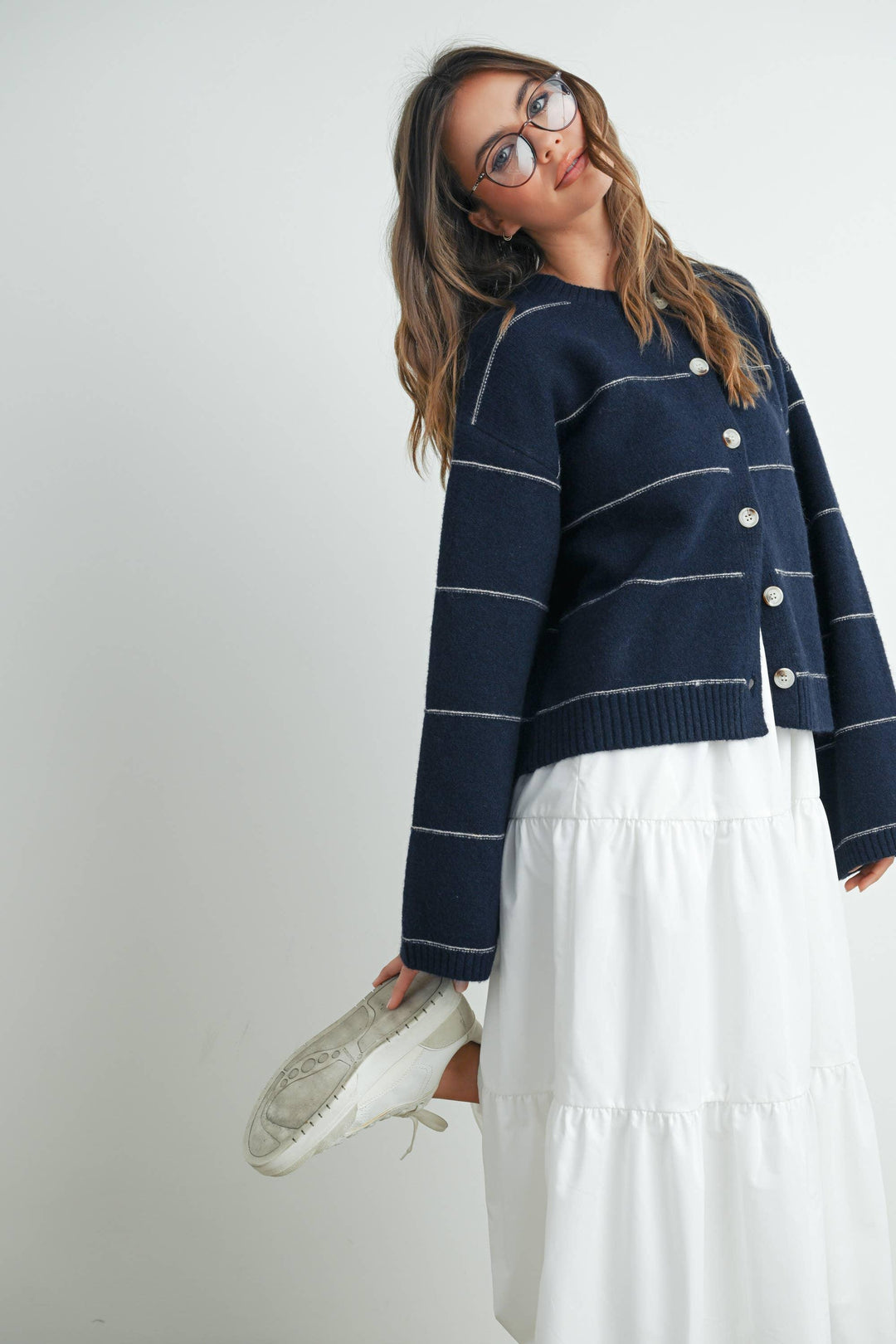 Navy striped cardigan with white buttons, paired with white tiered skirt and sneakers for coastal style
