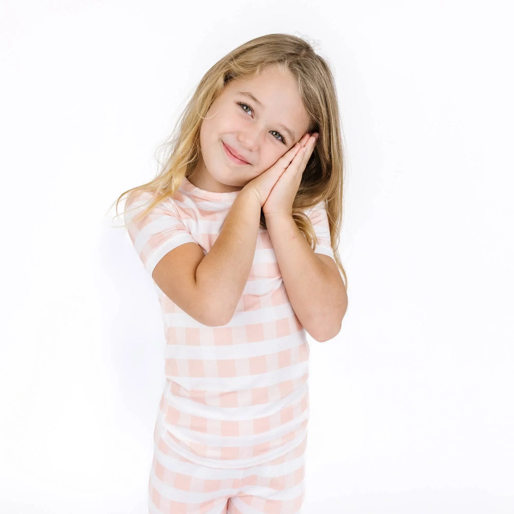 Girl in pink and white gingham pajama set, cozy sleepwear for kids