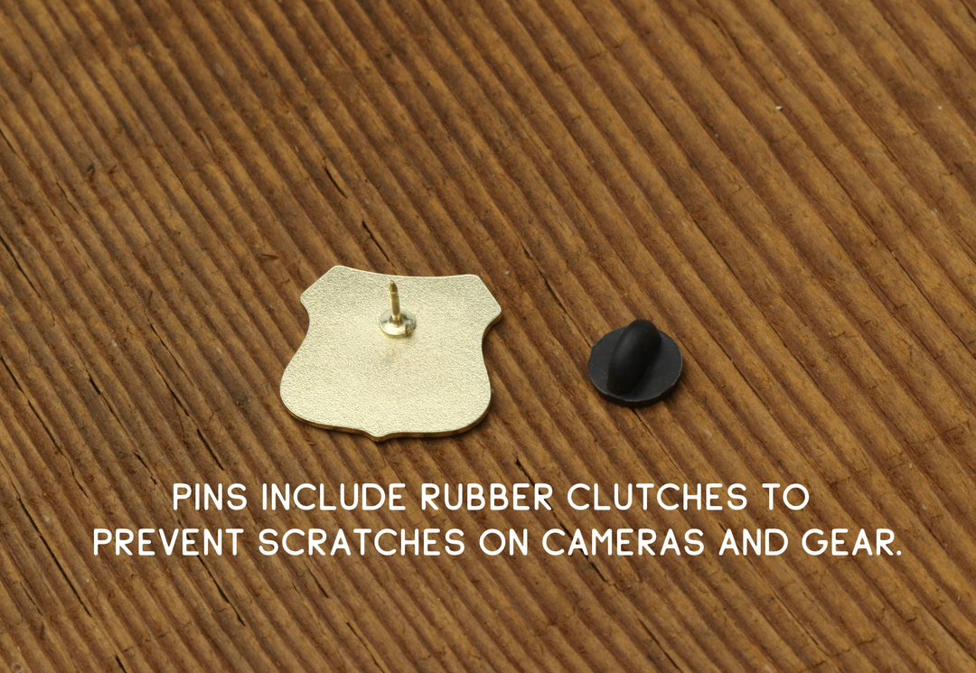 Gold pin with rubber clutch for cameras and gear on wood