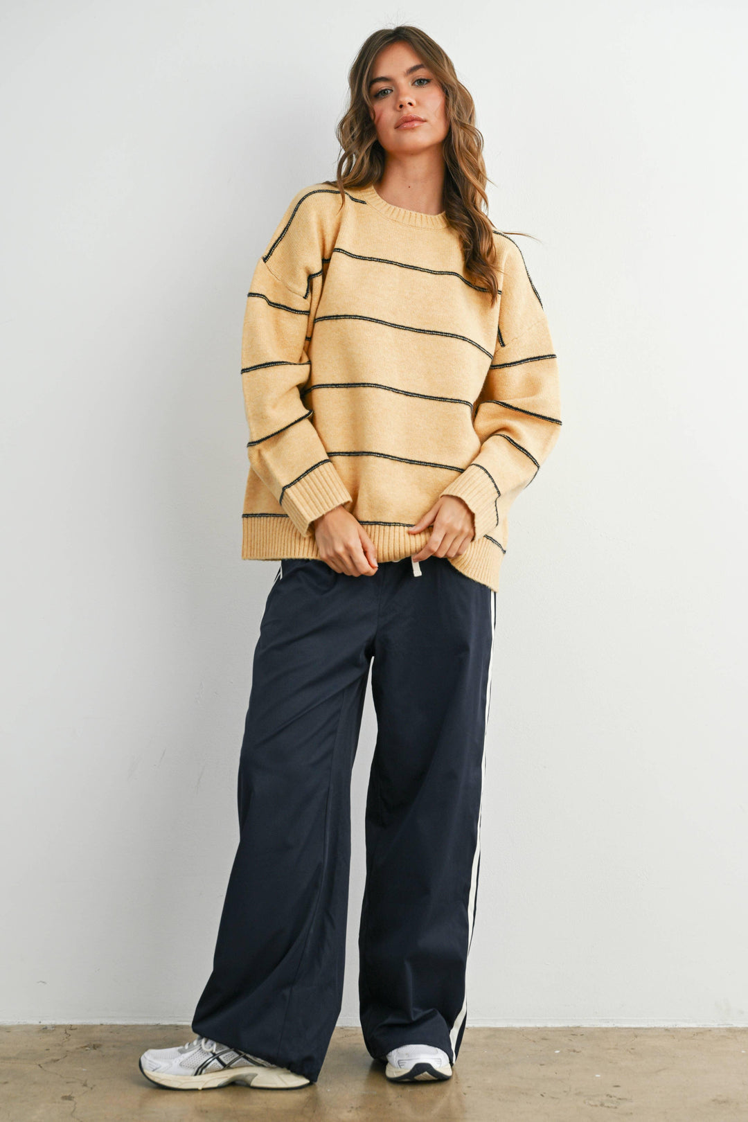 Woman in cozy yellow striped sweater and navy track pants, PNW outdoor style