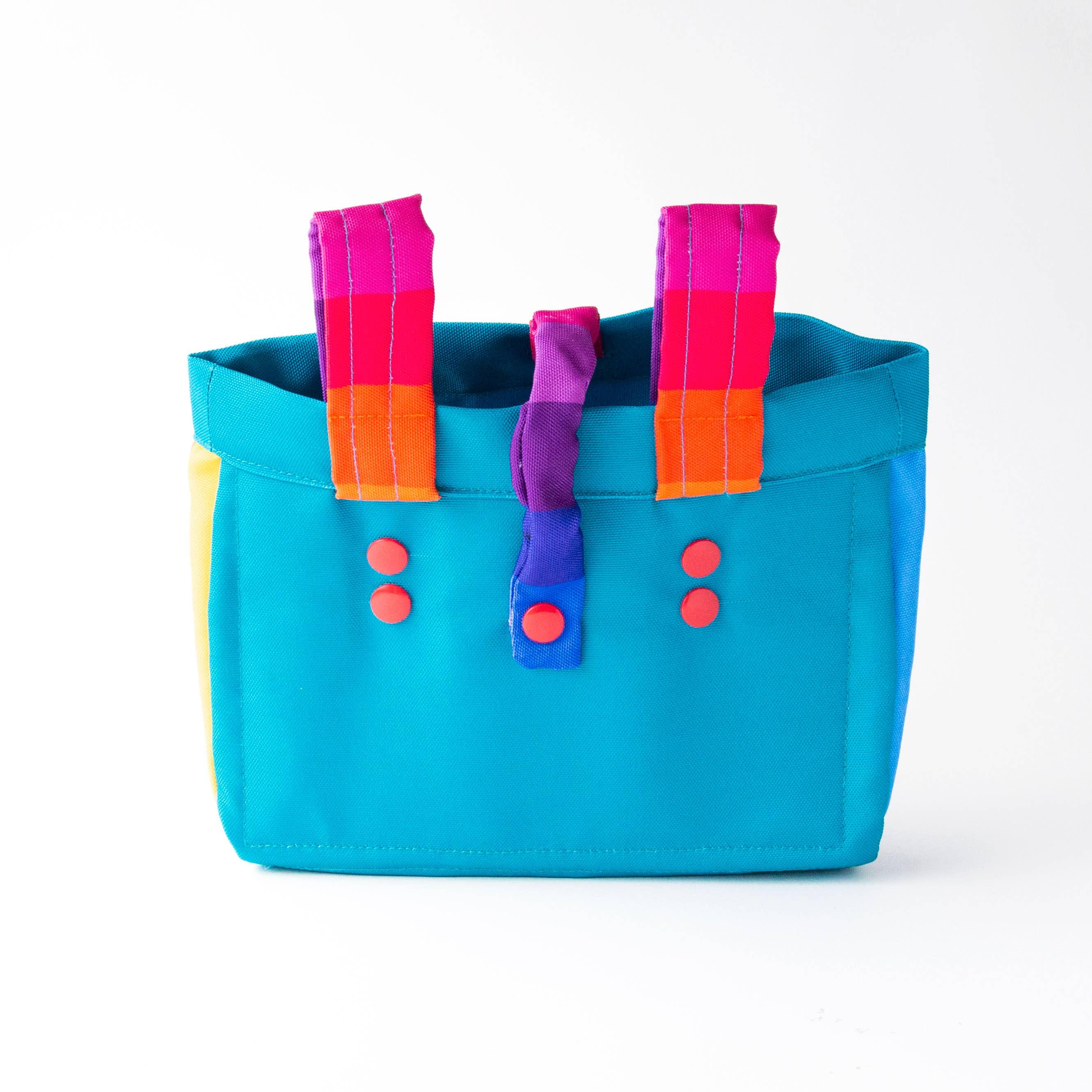 Vibrant turquoise tote with rainbow straps and red buttons, perfect for beach days and outdoor adventures.