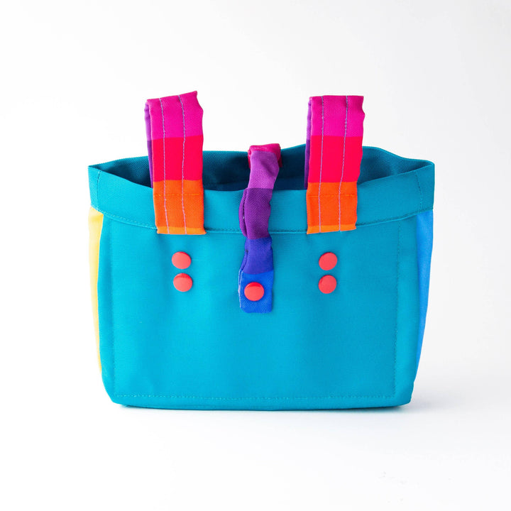 Vibrant turquoise tote with rainbow straps and red buttons, perfect for beach days and outdoor adventures.