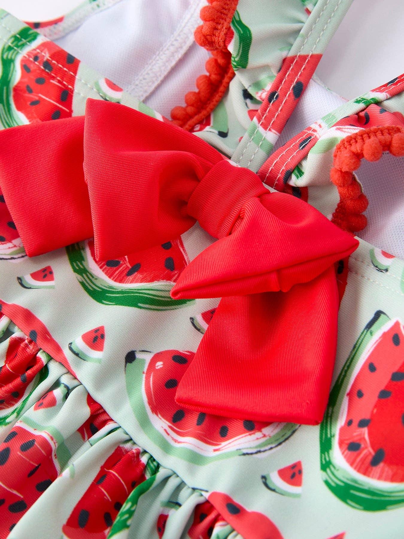 Watermelon print swimsuit with red bow and pom-pom straps for beach days and summer adventures.