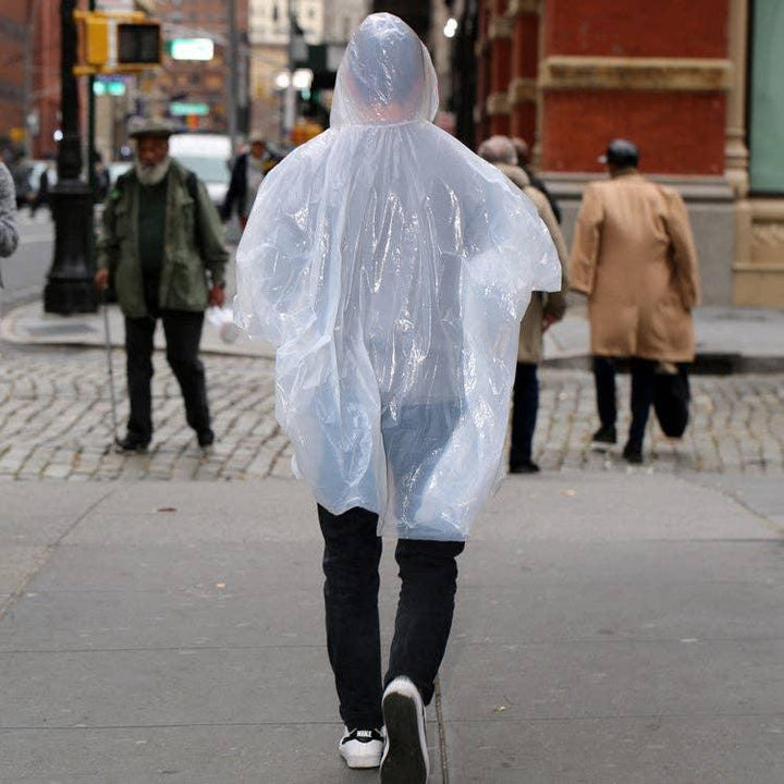 Clear rain poncho worn on city sidewalk, perfect for urban adventures and coastal weather