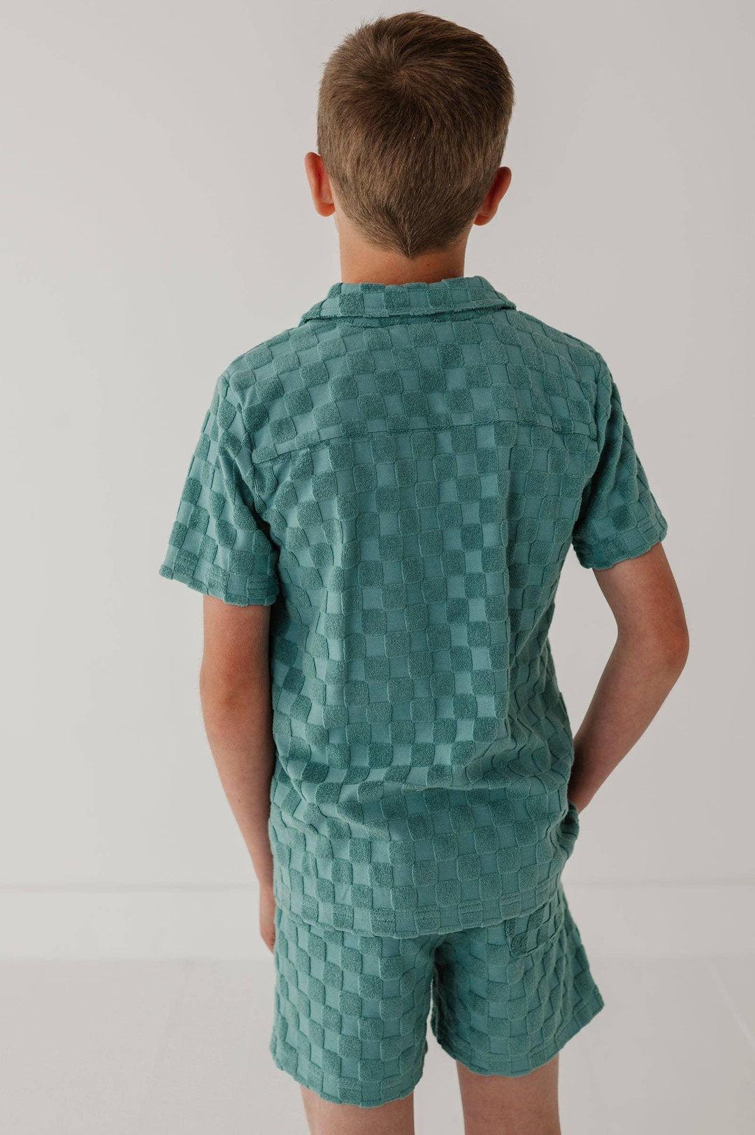 Boy wearing teal checkered short sleeve shirt and shorts set, coastal style kids outfit