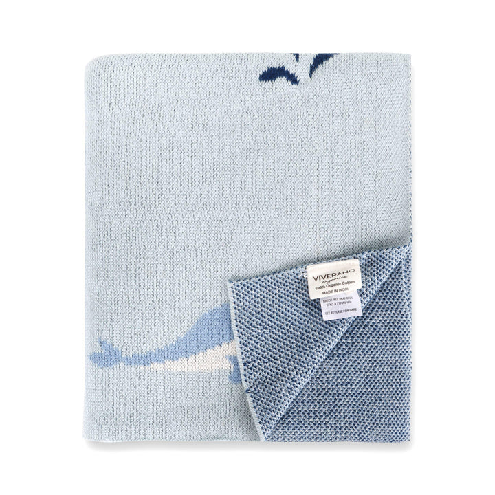 Light blue organic cotton knit blanket with whale design, soft texture, Viverano tag visible