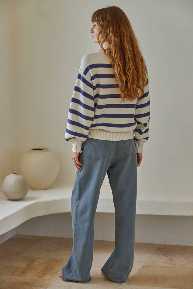Woman in striped sweater and wide-leg denim pants, coastal style outfit