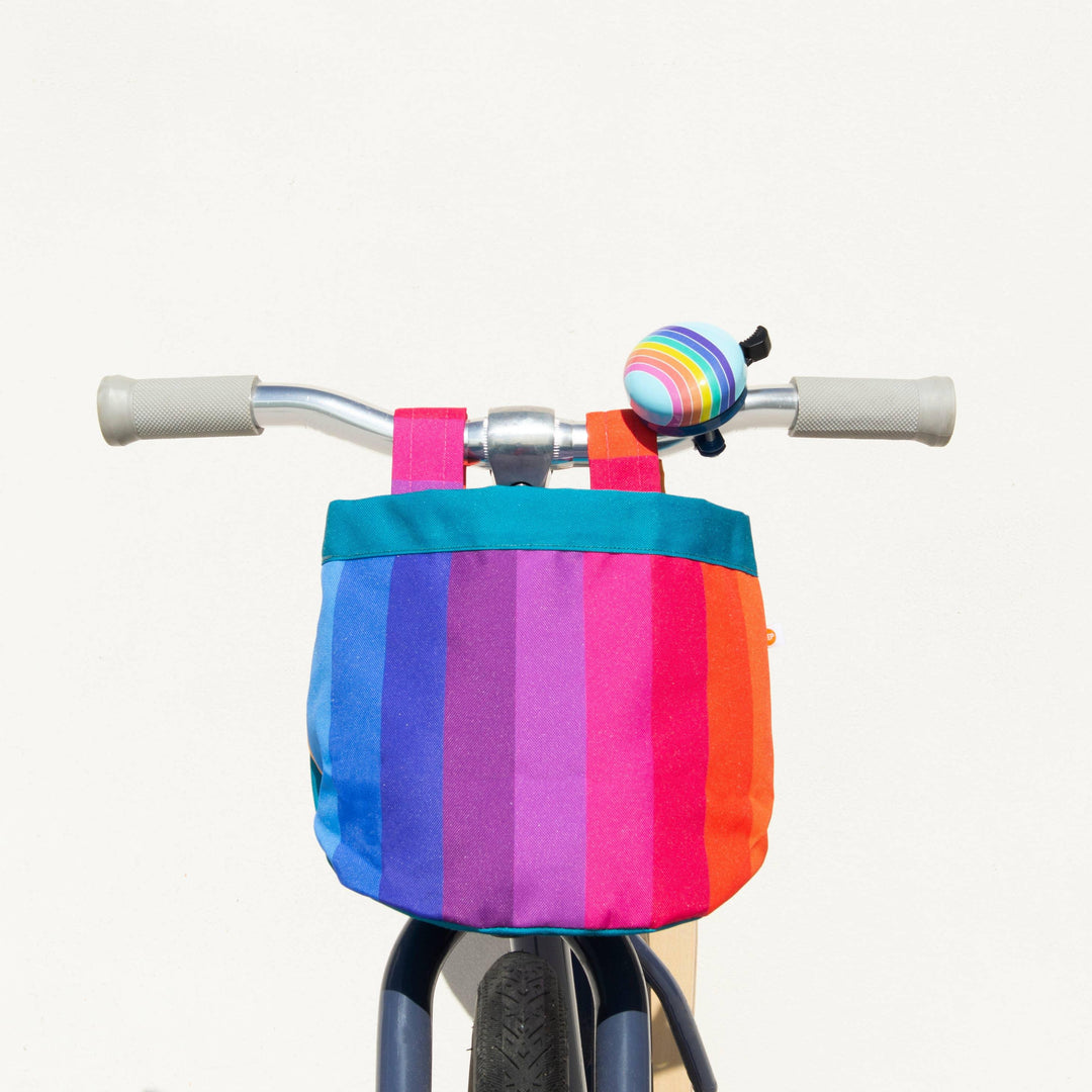 Kids bike with rainbow striped basket and matching bell, perfect for beach days and bike rides