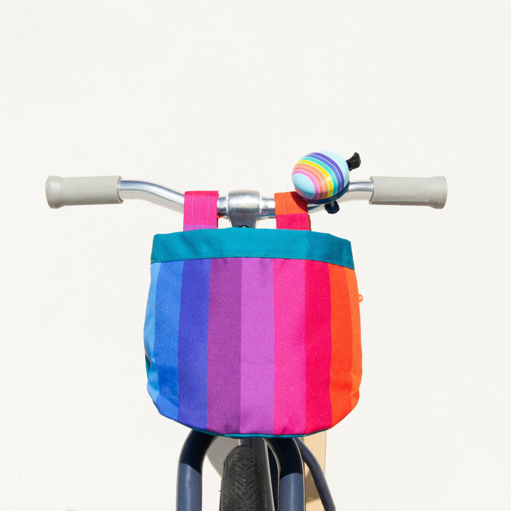 Kids bike with rainbow striped basket and matching bell, perfect for beach days and bike rides
