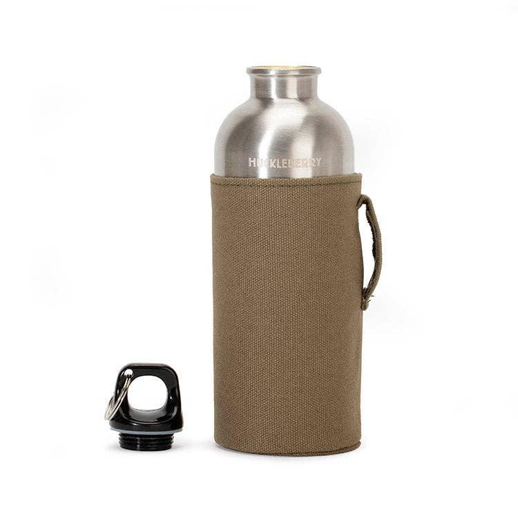 Stainless steel Huckleberry water bottle with tan canvas sleeve and black cap, perfect for outdoor adventures.
