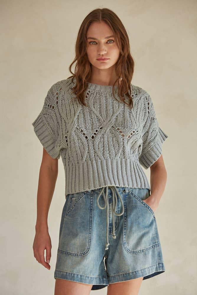 Woman wearing cozy knit short sleeve top with denim drawstring shorts, casual summer outfit